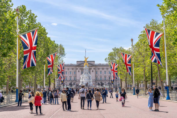 London England - May 29 2023: People Walking Down the Mall Towards Buckingham Palace With Union Jack Flags