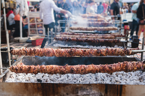 Easter in Greece, process of cooking traditional greek Easter dish - grilled Kokoretsi, a lamb or goat intestines and offal, grilling Kokoreç in the streets of Athens, Greece, roasted kokorec rolls
