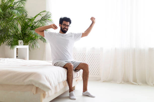 istock Good Rest. Happy Young Indian Man Stretching Muscles While Sitting On Bed 1791837165