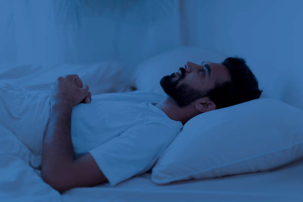 istock Awake sleepless upset indian man lying in bed alone at night 1791837178