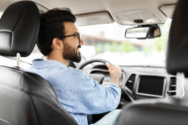 istock Handsome young indian man looking at road, sitting in car 1791837706
