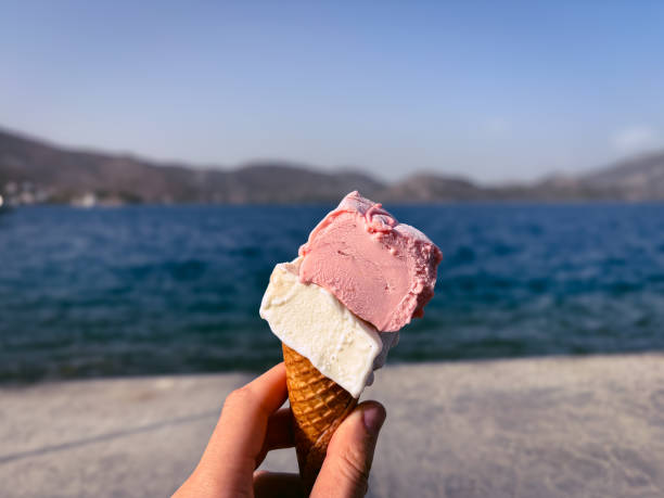 istock Hand holding colorful ice cream cone sea background 1791842455
