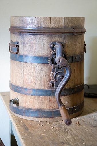 A vintage wooden butter churn on a table