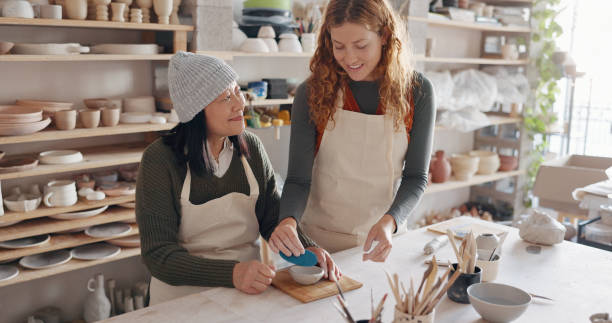 istock Pottery class, teacher and artist in workshop for art learning with clay sculpting or molding. Creative, teaching and woman sculptor with mentor manufacturing a mud ceramic design product in a studio 1791907615