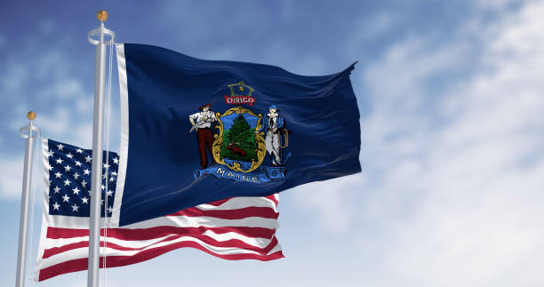 istock US and Maine Flags Wave Against Blue Sky 1791909201