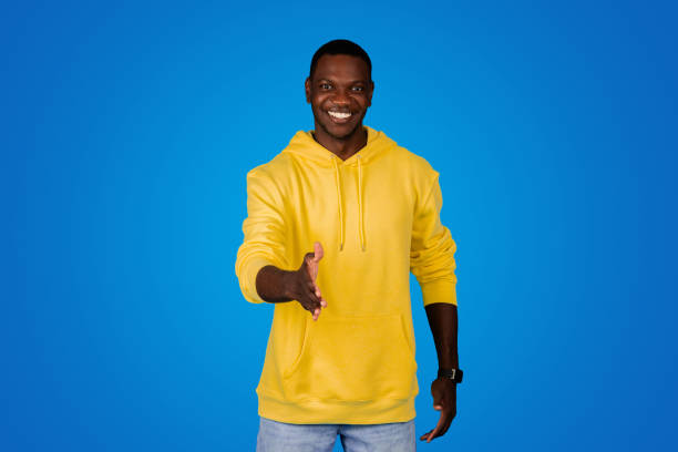 istock Happy young black guy shaking hands and saying hello, isolated on blue background 1791909779