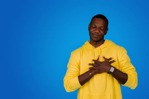istock Positive young black guy with closed eyes presses hands to chest, make thanks gesture 1791909795