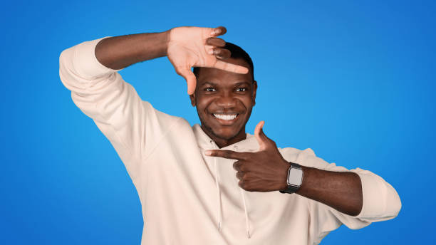 istock Cheerful young african american man in sweatshirt doing sign with hands frame or lens 1791910253