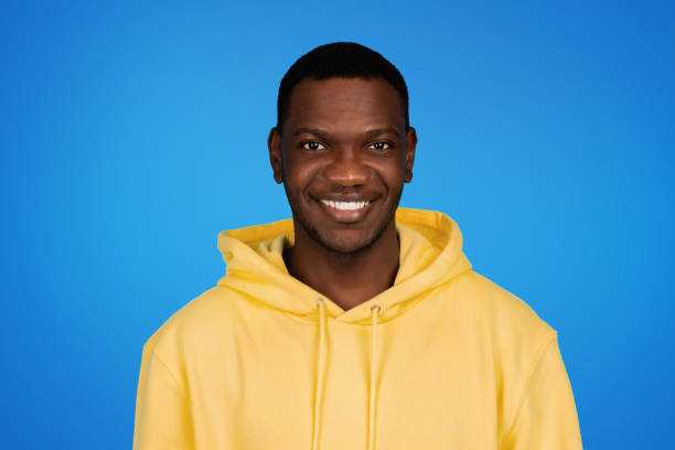 istock Happy young african american guy in sweatshirt looking at camera, isolated on blue studio background, close up 1791910350