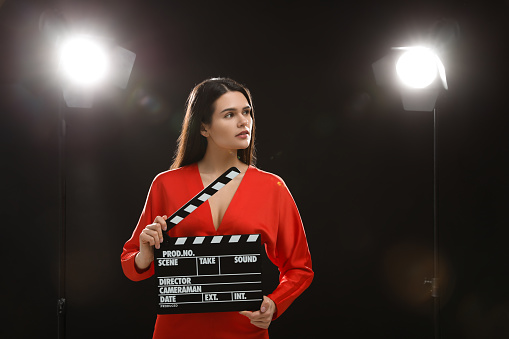 Actress with clapperboard on stage. Film industry