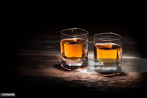 Zbliżenie Z Dwie Szklanki Whisky Na Drewniany Stół - zdjęcia stockowe i więcej obrazów Kieliszek do wódki - Kieliszek do wódki, Whisky, Alkohol - napój