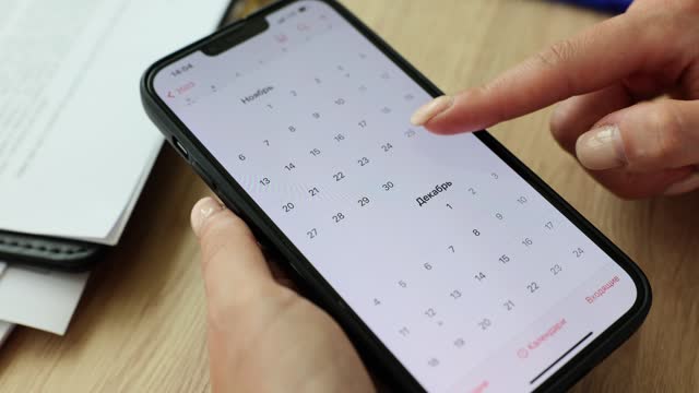 Closeup of woman using calendar application on mobile device