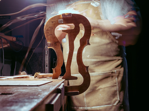 luthier violin maker luthier working with violin mould on center bot, corner blocks , bend ribs for a new classic handmade violin using mold long exposure blended frames.