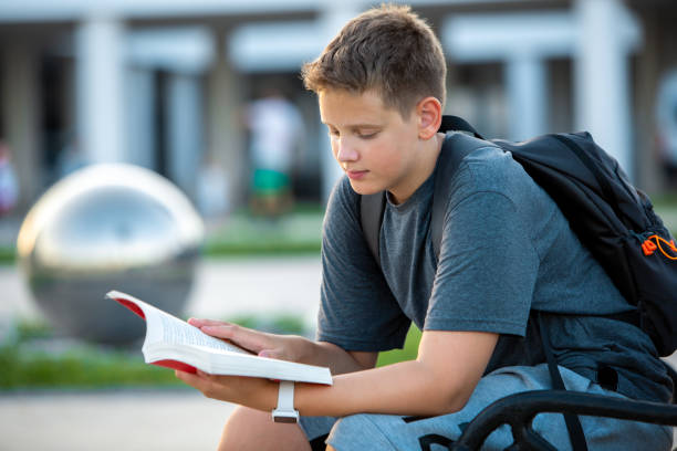 Scholar's Retreat: Teen Relaxes with a Book in Modern School Setting stock photo