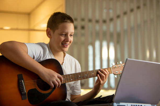 istock Melodic Genius: Teenager Embraces Digital Learning with Guitar 1792054955