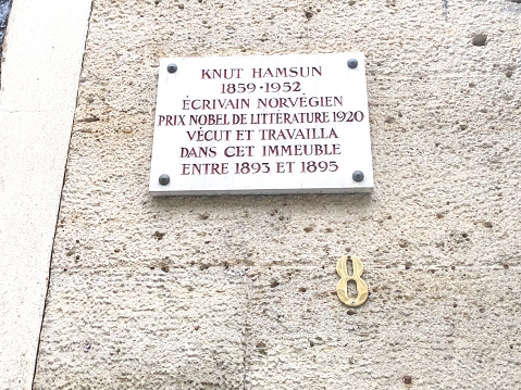 Paris, France: A marble plaque commemorating writer and Nobel Prize winner Knut Hamsun on a wall at 8 Rue de Vaugirard in the 6th arrondissement. The inscription reads, in English, “Knut Hamsun (1859-1952) Norwegian writer, Nobel Prize in Literature 1920, lived and worked in this building between 1893 and 1895.”