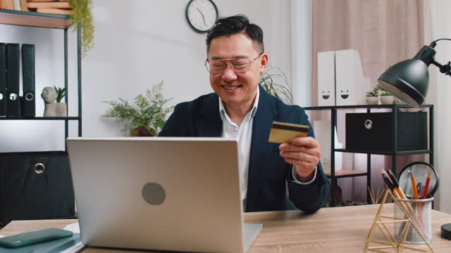 Business man making online purchase payment shopping with credit bank card and laptop at office