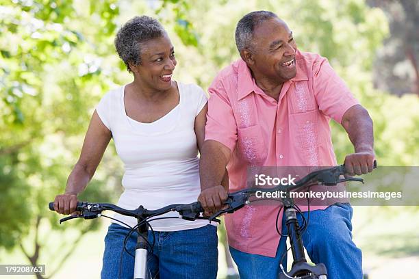 Older Couple Riding Bikes In Park Stock Photo - Download Image Now - Senior Adult, Couple - Relationship, African Ethnicity