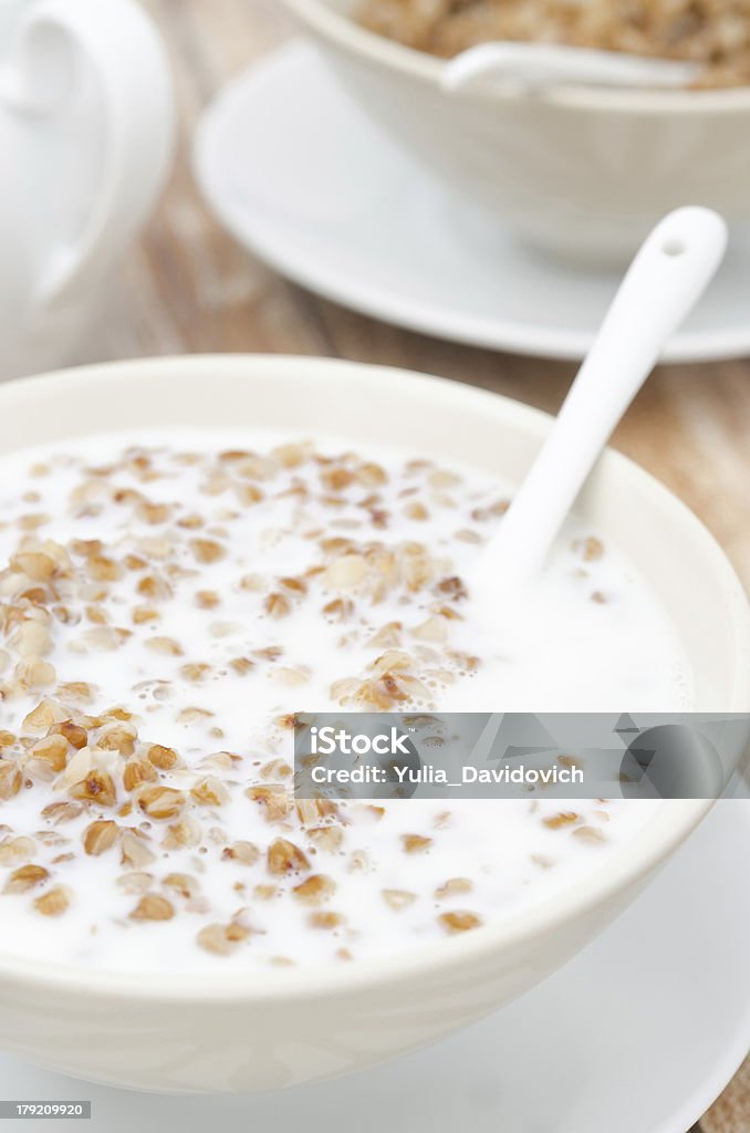Bollito grano saraceno con il latte in una ciotola bianca, vista dall'alto - Foto stock royalty-free di Alimentazione sana