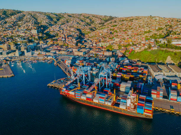 Ship with containers and city on the mountain in the background