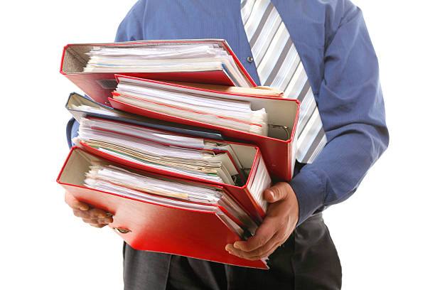 Male office worker carrying a stack of files Man holding stack of folders. Pile with old documents and bills. Isolated on white background tabs ring binder office isolated stock pictures, royalty-free photos & images