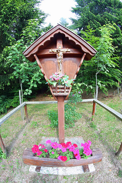 wooden capitellum with Jesus crucified and a vase of flowers wooden capitellum with Jesus crucified and a vase of flowers in the mountains what mountain was jesus crucified on stock pictures, royalty-free photos & images