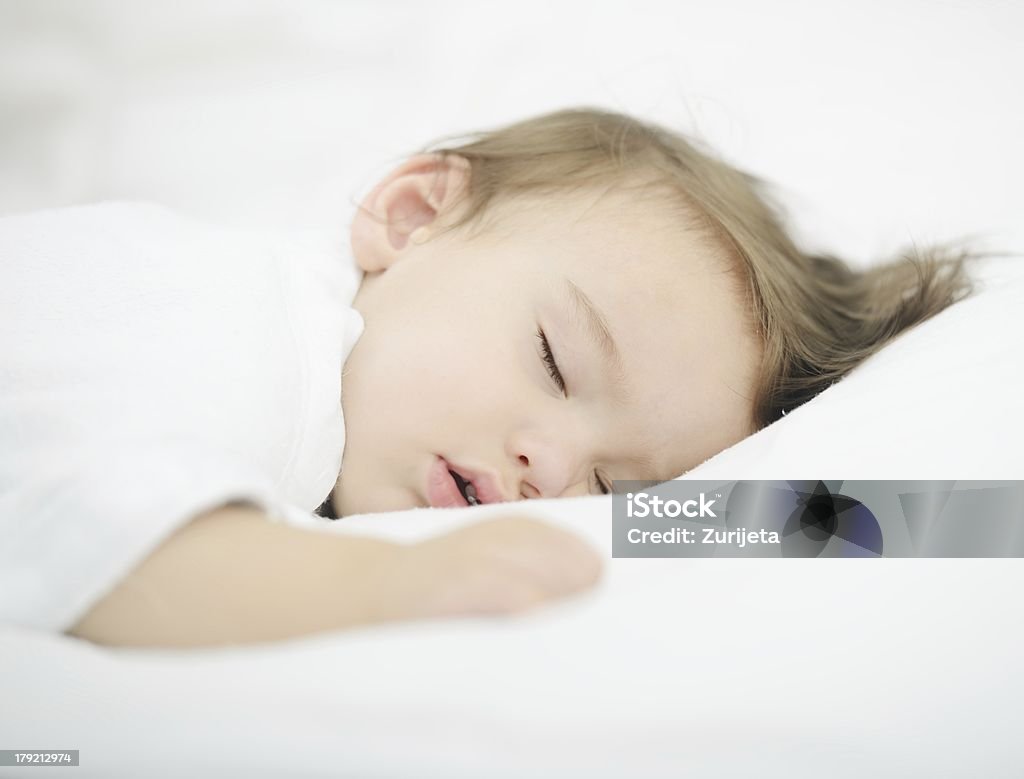 Baby sleeping on white bed Baby sleeping on white bed with copy space 12-17 Months Stock Photo