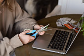 Young woman cutting credit card with scissors