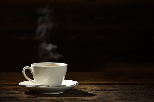 Coffee cup with smoke on vintage table