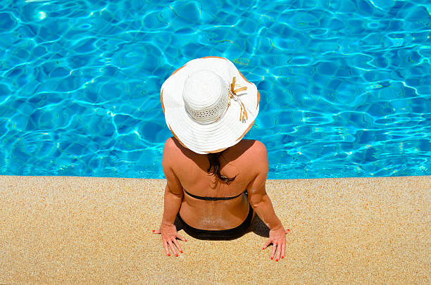 istock Young woman relaxing by the pool 179214943