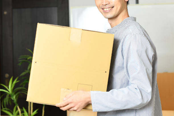 istock Young Asian man smiling and carrying cardboard at home 1792157865