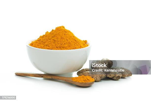 Tumeric Powder In A White Bowl With Wooden Spoon Stock Photo - Download Image Now - Turmeric, Curry Powder, Ground - Culinary