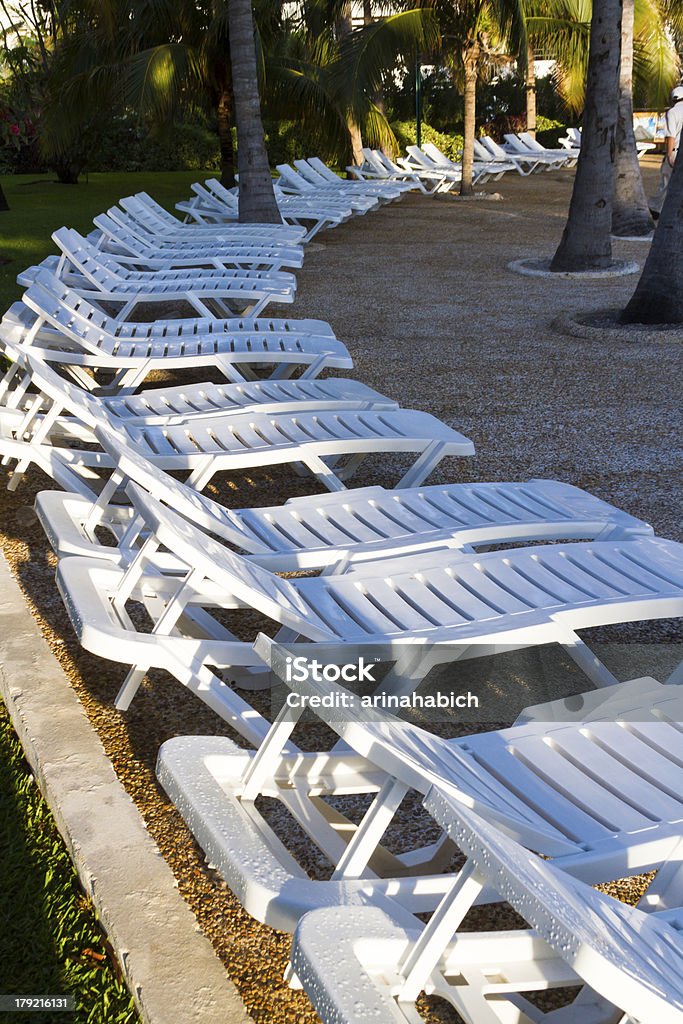 Pool chairs White pool chairs near the swimming pool at vacation resort in Mexico. Blue Stock Photo