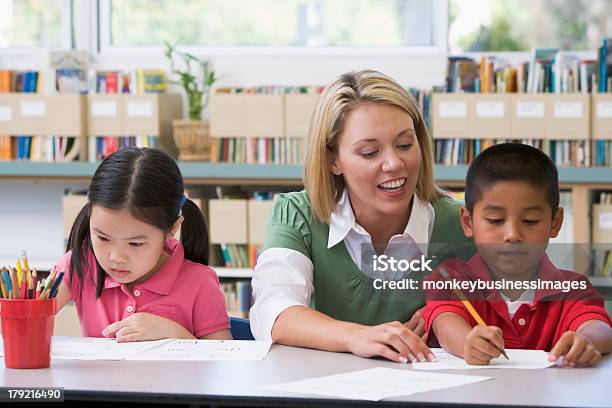 Kindergarten Teacher Helping Students With Writing Skills Stock Photo - Download Image Now