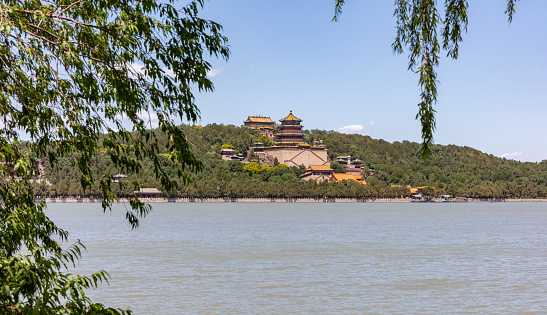Classical style cruise ship on the lake of the Summer Palace, a classical royal garden in Beijing in summer, with Wanshou Mountain in the distance