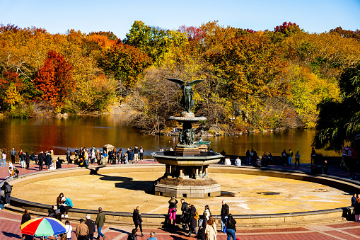 The Besthesda Fountain in Central Park NYC drained for the winter surrounded by visitors, the cool pond water and colorful fall foliage