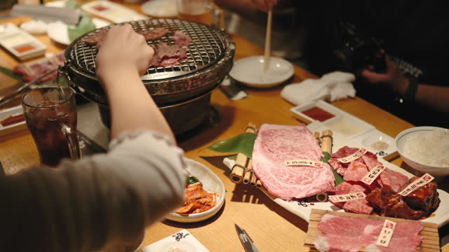Asian tourist women eating Yakiniku Wagyu A5 and most expensive meat at osaka japan