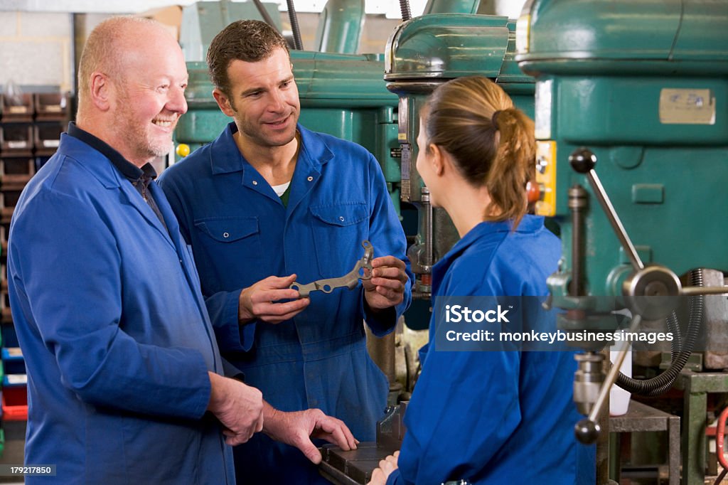 Drei machinists im Arbeitsbereich von Maschine sprechen - Lizenzfrei Arbeiten Stock-Foto