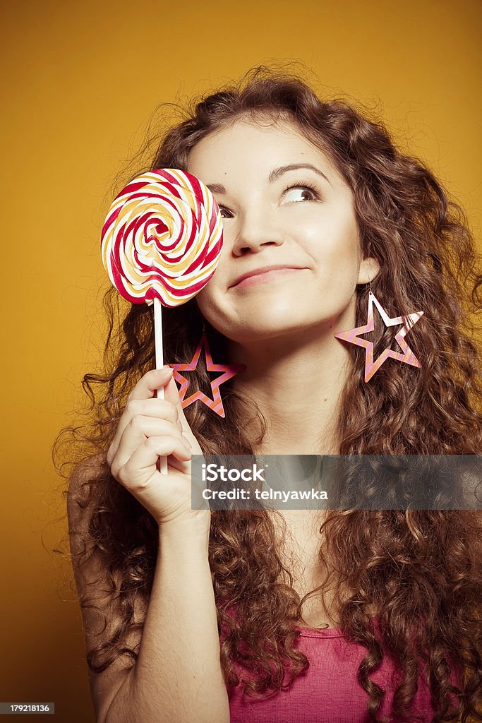 happy young woman with lollipop happy young woman with lollipop on yellow background Adult Stock Photo