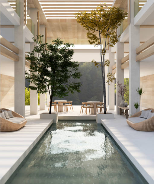 Interior design of a modern, luxurious, spacious hotel indoor lounge with an indoor pool. Interior design of a modern, luxurious, spacious hotel indoor lounge or lobby area with an indoor pool, cosy wicker couches, trees, a high ceiling, and a large window. 3d render, 3d illustration thai decor stock pictures, royalty-free photos & images
