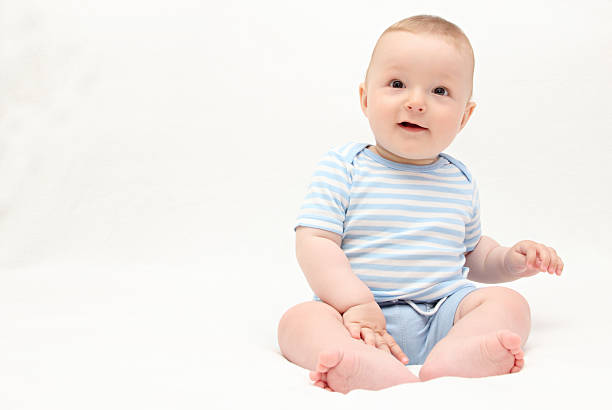 istock beautiful laughing happy baby boy sitting on bed 179219043