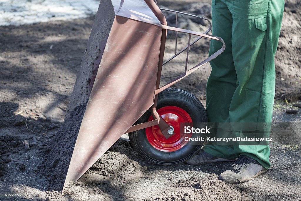 Trabajador vacía una carretilla - Foto de stock de Adulto libre de derechos