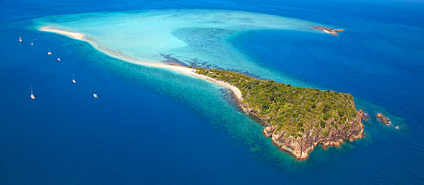 Aerial remote island in Whitsundays with surrounding coral reef stock photo