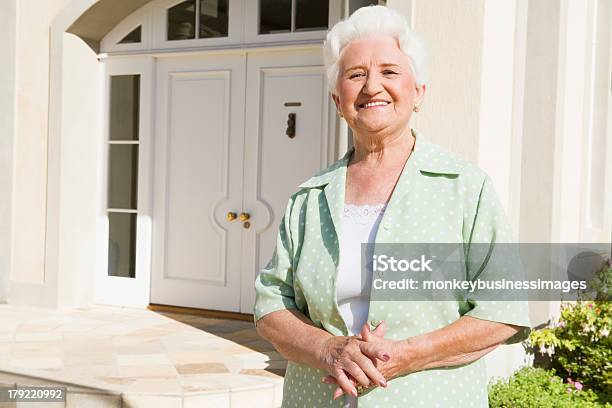 Senior Frau Stehend Vor Haus Stockfoto und mehr Bilder von 70-79 Jahre - 70-79 Jahre, Aktiver Senior, Alter Erwachsener