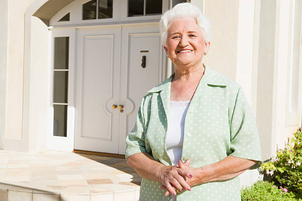 istock Senior woman standing outside house 179220992