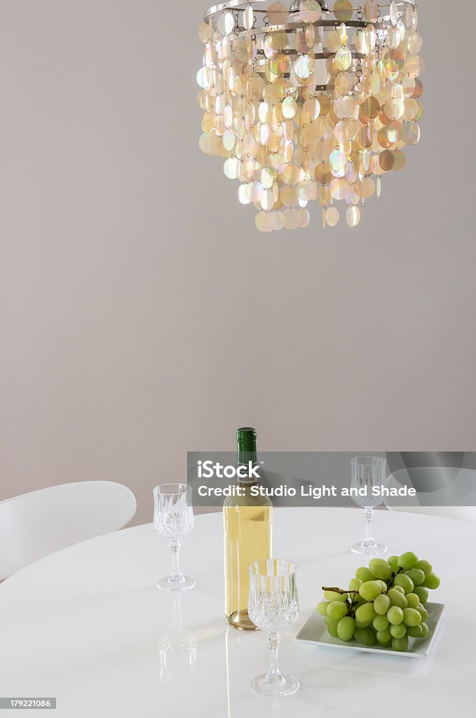 Decorativo chandelier y botella de vino en la tabla - Foto de stock de A la moda libre de derechos