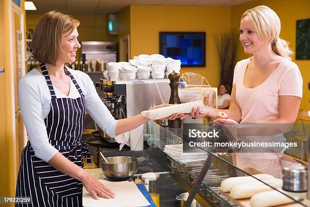 Foto de Mulher Em Pé No Balcão No Restaurante Servindo Cliente E Sorrindo e mais fotos de stock de 40-49 anos