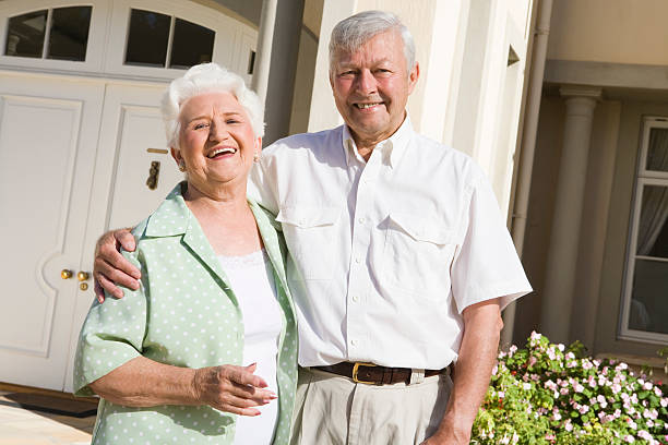 istock Senior couple standing outside house 179221418