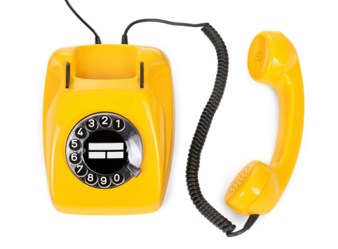 Pastel colour image of old rotary dial telephone. Cyan device on yellow background. 3D illustration.