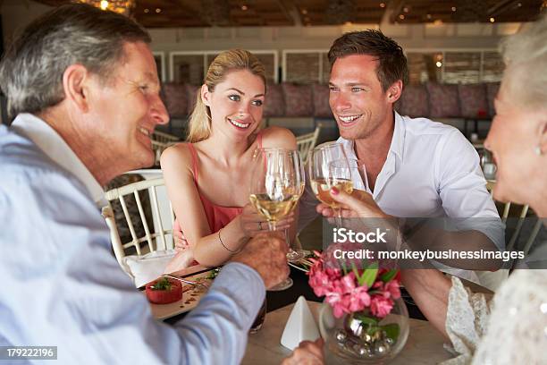 Foto de Grupo De Amigos Aproveitando A Refeição Em Restaurante e mais fotos de stock de 20 Anos